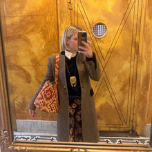 Load image into Gallery viewer, Person taking a mirror selfie in front of a gold door with geometric patterns.
