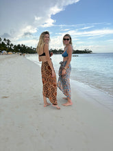 Load image into Gallery viewer, Two women standing on a sandy beach with ocean and sky in the background
