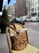 Load image into Gallery viewer, ikat print basket tote bag on a chair with a city street background
